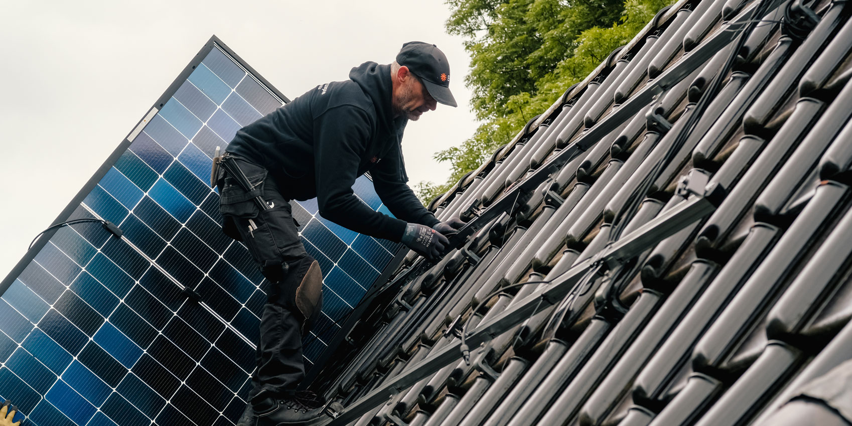 Monteur installiert eine Solaranlage auf dem Dach